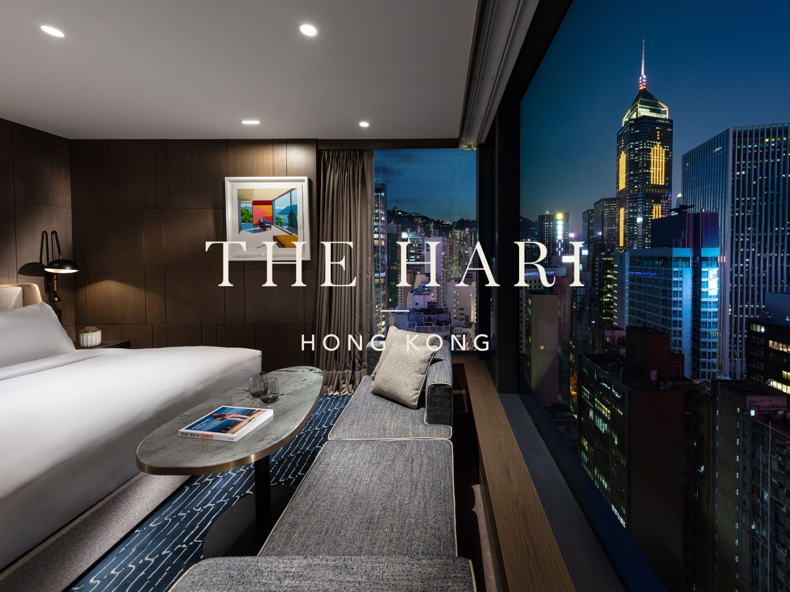 A white property logo is overlaid onto an image of the 1 King Studio Suite of The Hari Hong Kong.